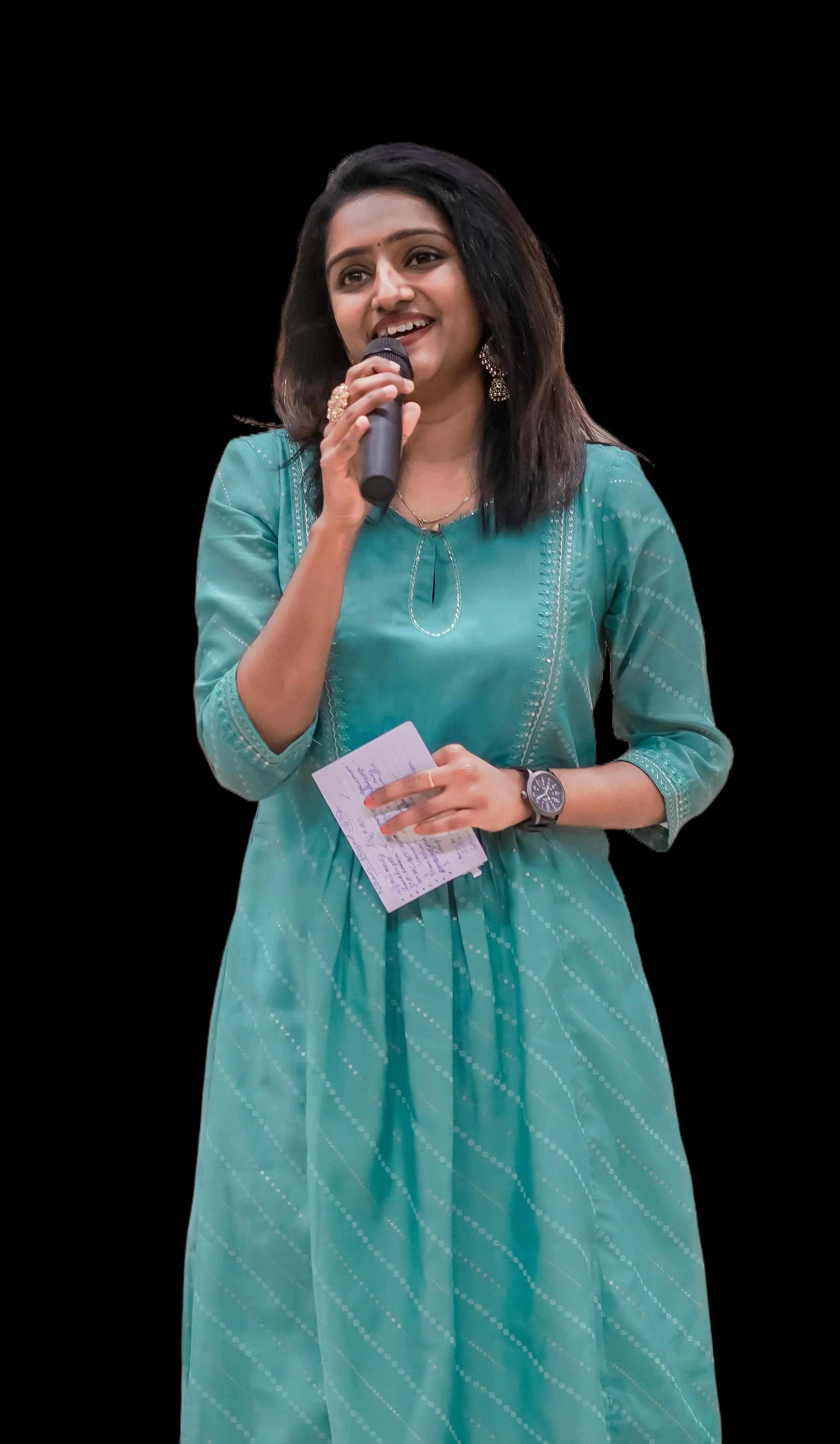 Riya Francis holding a microphone on stage